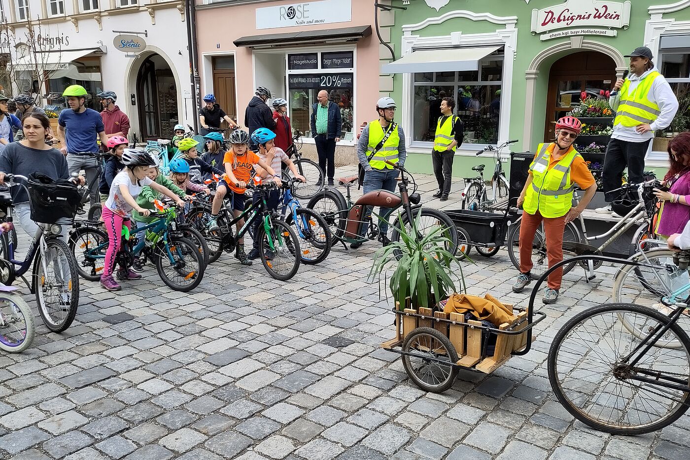 Mann mit Micro und Kinder auf Fahrrädern
